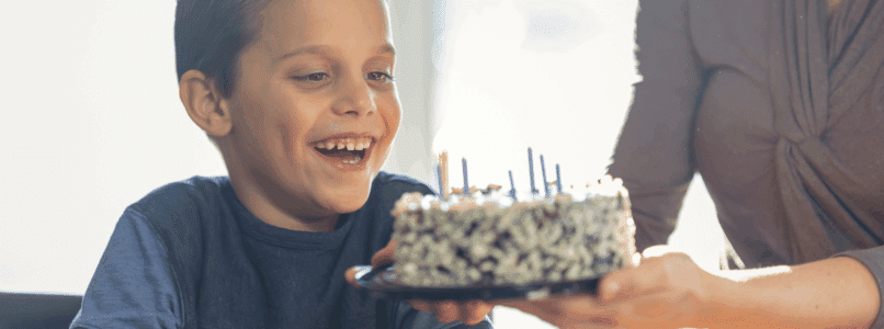 A boy blows out candles on a birthday cake.